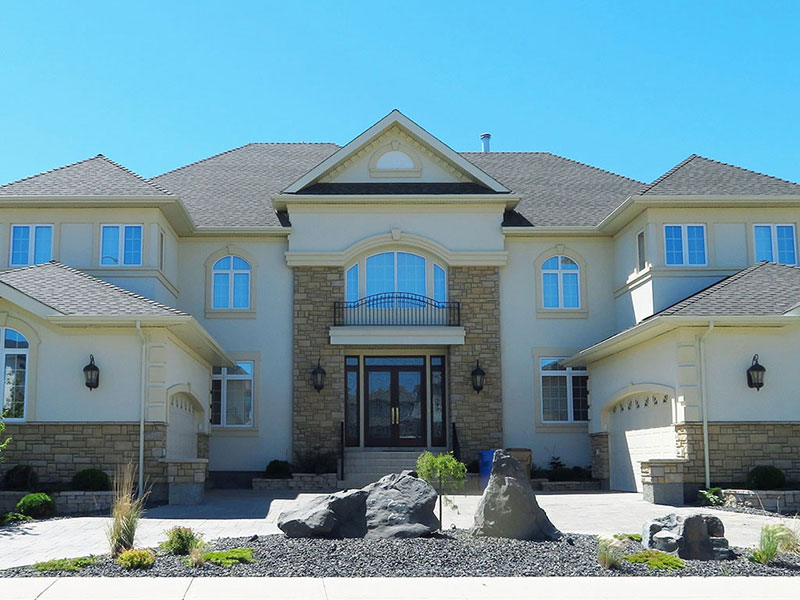 Cream colored custom house with a stone facade.